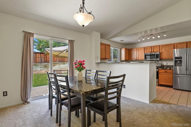 dining room with light carpet and vaulted ceiling