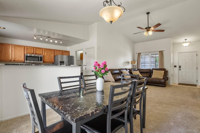 carpeted dining space featuring ceiling fan and lofted ceiling