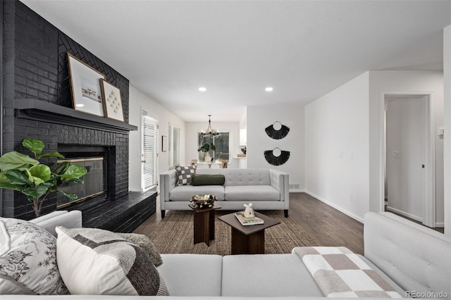 living room featuring dark hardwood / wood-style floors, a chandelier, and a fireplace