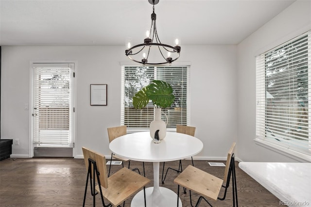 dining room with dark hardwood / wood-style flooring and a notable chandelier