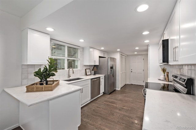 kitchen featuring sink, light stone counters, dark hardwood / wood-style flooring, stainless steel appliances, and white cabinets