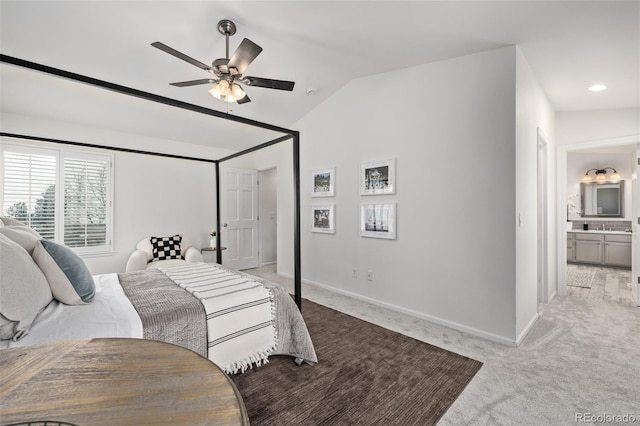 bedroom with light colored carpet, ceiling fan, vaulted ceiling, and ensuite bath