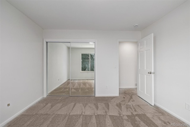 unfurnished bedroom with a closet and carpet flooring