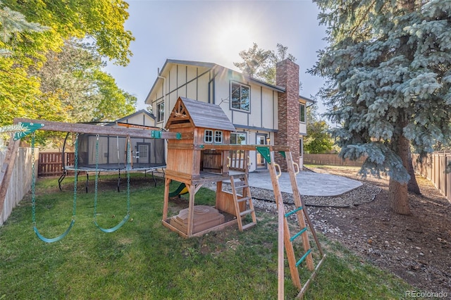 rear view of house with a patio, a yard, a shed, and a trampoline