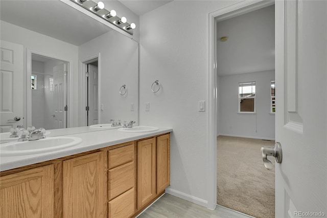 3590 S Malaya St, Aurora, CO 80013 - bathroom featuring baseboards, double vanity, and a shower