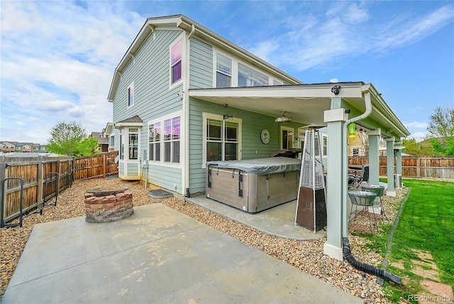 3590 S Malaya St, Aurora, CO 80013 - back of property featuring a hot tub, an outdoor fire pit, a patio area, and a fenced backyard