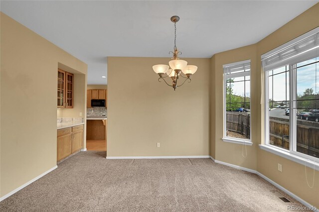 3590 S Malaya St, Aurora, CO 80013 - unfurnished dining area featuring a chandelier, baseboards, and light carpet