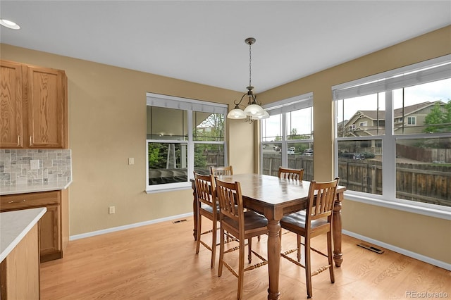 3590 S Malaya St, Aurora, CO 80013 - dining area featuring light wood-style flooring, a chandelier, and baseboards
