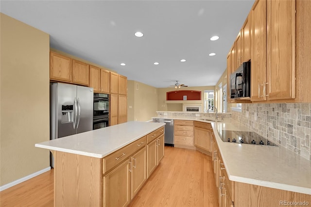 3590 S Malaya St, Aurora, CO 80013 - kitchen featuring black appliances, light wood-style floors, a sink, decorative backsplash, and light countertops