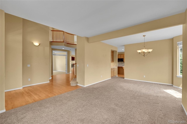 3590 S Malaya St, Aurora, CO 80013 - unfurnished living room with light colored carpet, a chandelier, baseboards, and light wood-style floors