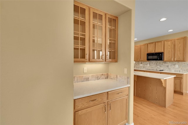 3590 S Malaya St, Aurora, CO 80013 - kitchen featuring black appliances, backsplash, light wood-style flooring, glass insert cabinets, and light brown cabinetry