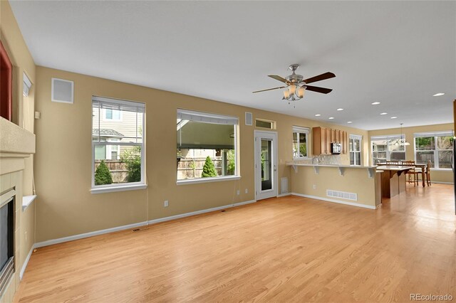 3590 S Malaya St, Aurora, CO 80013 - unfurnished living room with plenty of natural light, ceiling fan, light wood finished floors, and recessed lighting