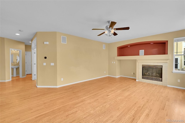 3590 S Malaya St, Aurora, CO 80013 - unfurnished living room with ceiling fan, light wood-style floors, a tile fireplace, baseboards, and recessed lighting