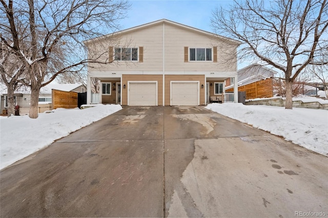 traditional home with a garage, driveway, and fence