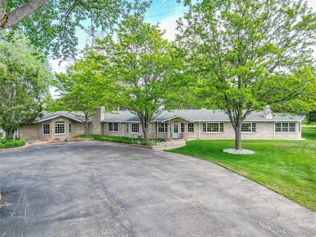 ranch-style home featuring a front yard