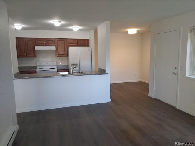 kitchen with white appliances, under cabinet range hood, dark wood-type flooring, a peninsula, and baseboards