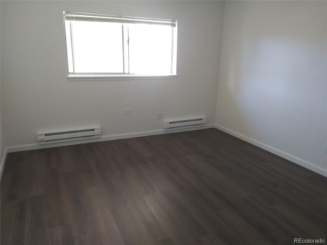 empty room featuring a baseboard radiator, dark wood finished floors, and baseboards