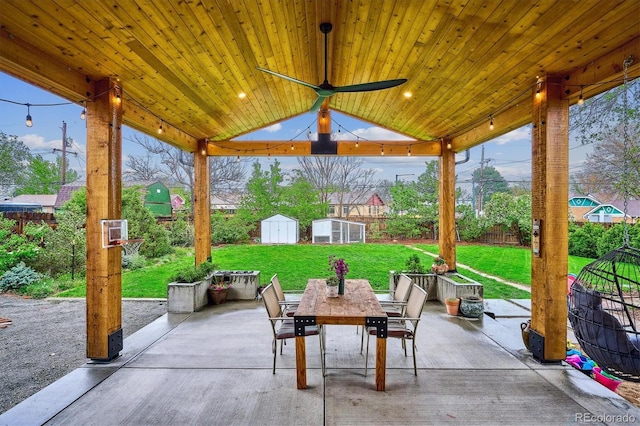 view of patio with a storage unit, outdoor dining area, and an outdoor structure