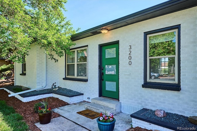 doorway to property with brick siding
