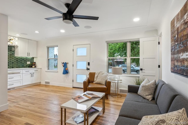 living room with light wood-style floors, plenty of natural light, ceiling fan, baseboards, and recessed lighting