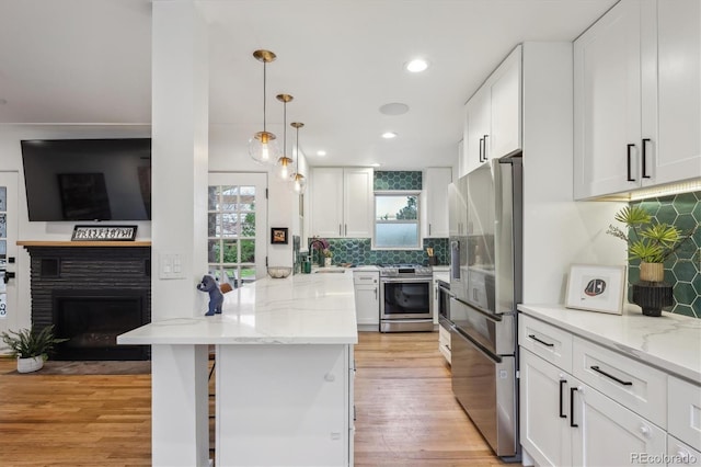 kitchen featuring appliances with stainless steel finishes, white cabinetry, light stone countertops, and recessed lighting