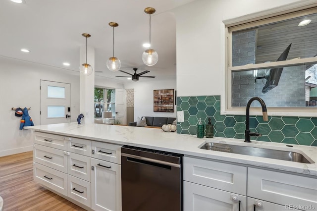 kitchen featuring dishwasher, a sink, decorative backsplash, white cabinetry, and recessed lighting