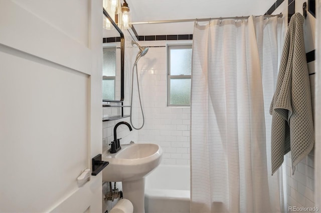 bathroom featuring shower / bath combination with curtain and a sink