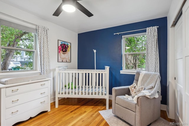 bedroom featuring a closet, light wood-style flooring, and ceiling fan