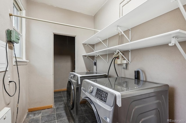 laundry area featuring washing machine and dryer and dark tile patterned flooring