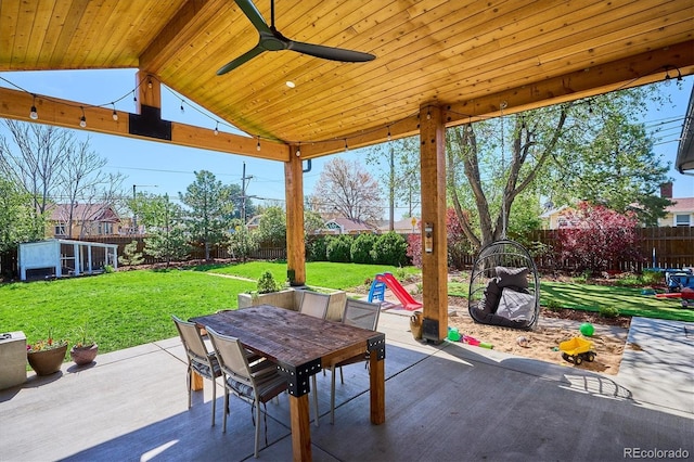 view of patio / terrace featuring outdoor dining area, ceiling fan, and an outbuilding