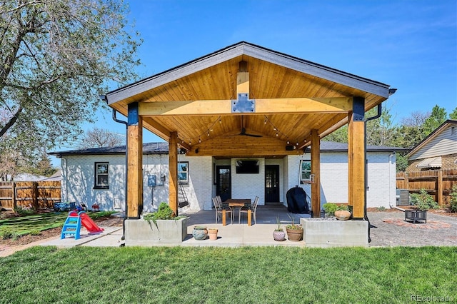 rear view of property with a patio area and an outdoor fire pit