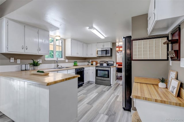 8696 E Easter Ave, Centennial, CO 80112 - kitchen with appliances with stainless steel finishes, a peninsula, white cabinets, and light wood-style floors