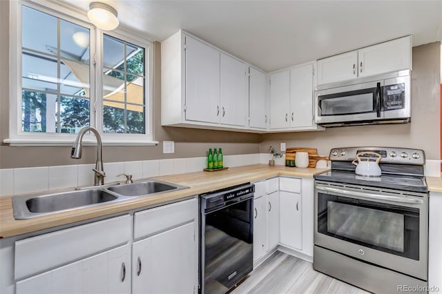8696 E Easter Ave, Centennial, CO 80112 - kitchen featuring appliances with stainless steel finishes, white cabinetry, light countertops, and light wood finished floors