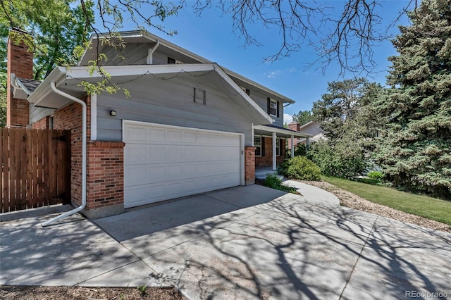 8696 E Easter Ave, Centennial, CO 80112 - view of property exterior featuring brick siding, concrete driveway, a chimney, a garage, and covered porch