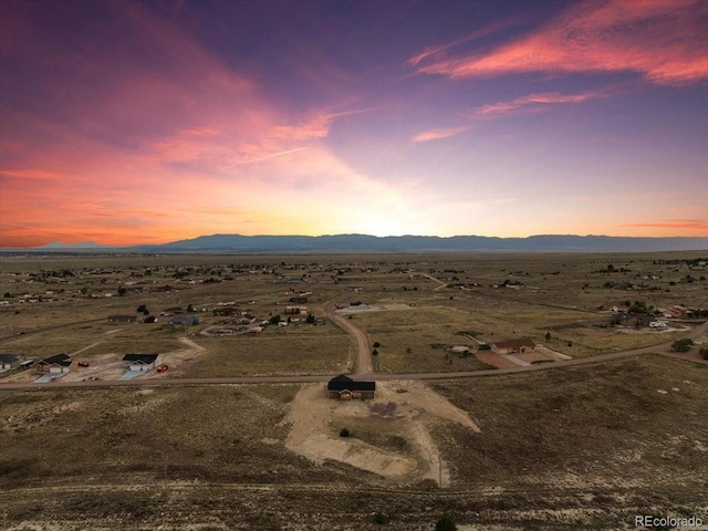 aerial view at dusk featuring a mountain view