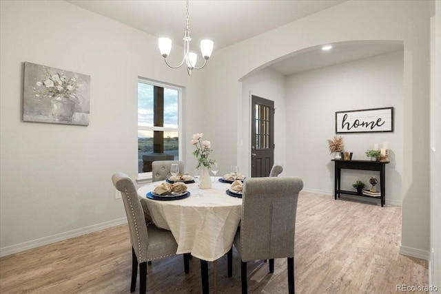 dining area featuring light wood-type flooring and a chandelier