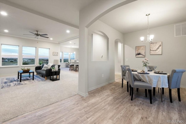 dining area with ceiling fan with notable chandelier and light carpet