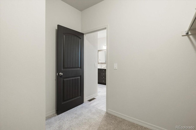 hallway featuring light colored carpet