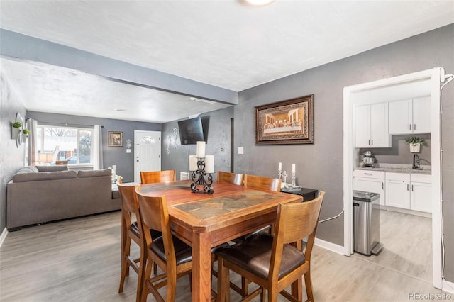 dining room with sink and light hardwood / wood-style flooring