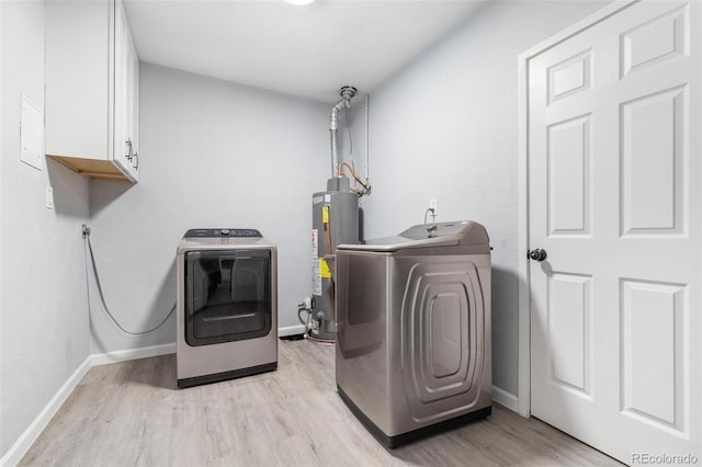 clothes washing area with light hardwood / wood-style flooring, gas water heater, washing machine and dryer, and cabinets