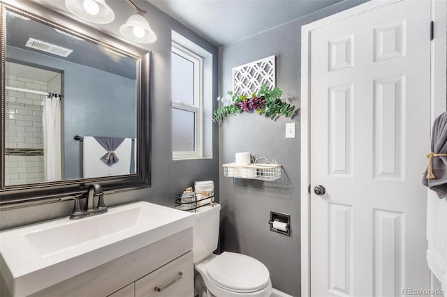 bathroom featuring a shower with curtain, vanity, and toilet