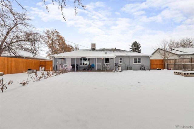 snow covered back of property with cooling unit