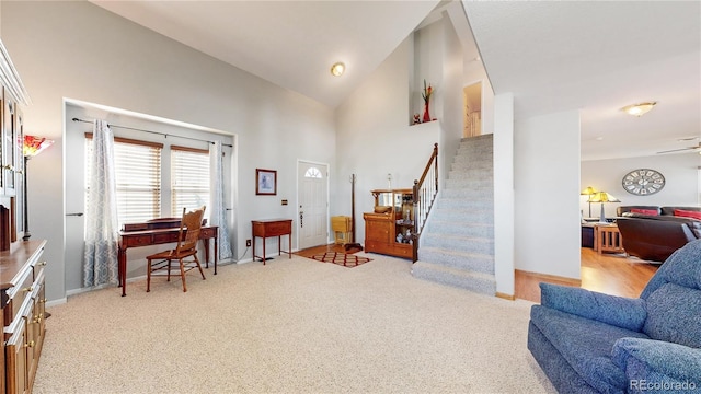 foyer entrance with ceiling fan, vaulted ceiling, and light colored carpet