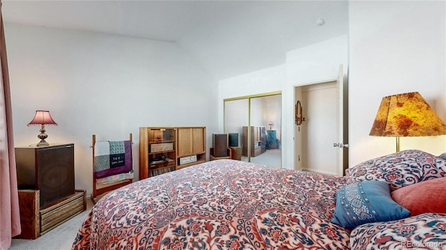 carpeted bedroom featuring a closet and lofted ceiling