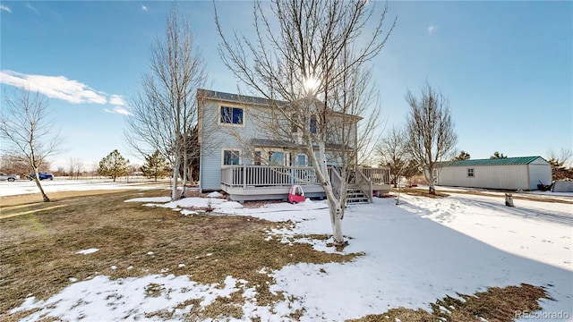 snow covered rear of property featuring a wooden deck