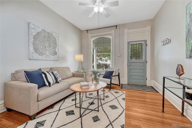 living room with baseboards, light wood-style flooring, and ceiling fan