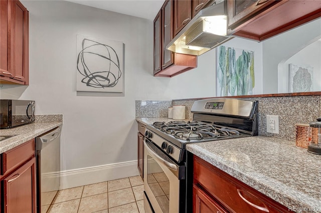 kitchen with appliances with stainless steel finishes, light countertops, baseboards, tasteful backsplash, and under cabinet range hood