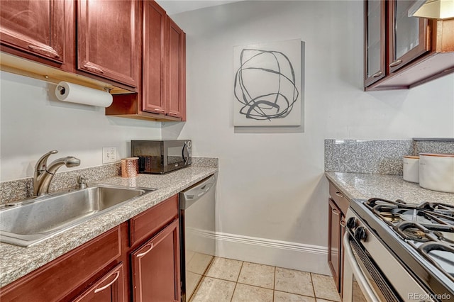 kitchen featuring appliances with stainless steel finishes, a sink, baseboards, light countertops, and light tile patterned flooring