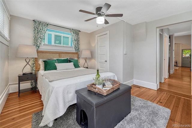 bedroom with baseboards, a ceiling fan, and wood finished floors
