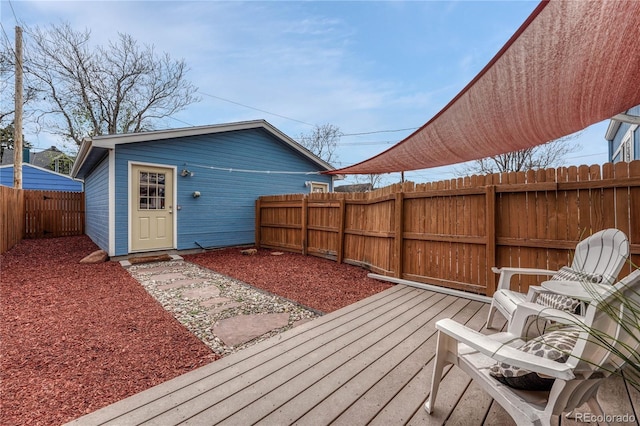 wooden terrace with a fenced backyard